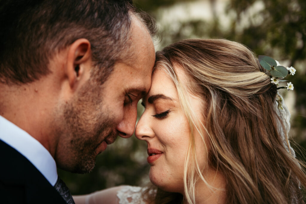 Forehead-to-forehead portrait of the couple during their Prosecco Hills wedding.