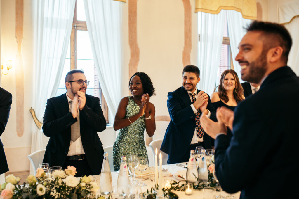 Guests clapping and smiling during entrance at the wedding reception.