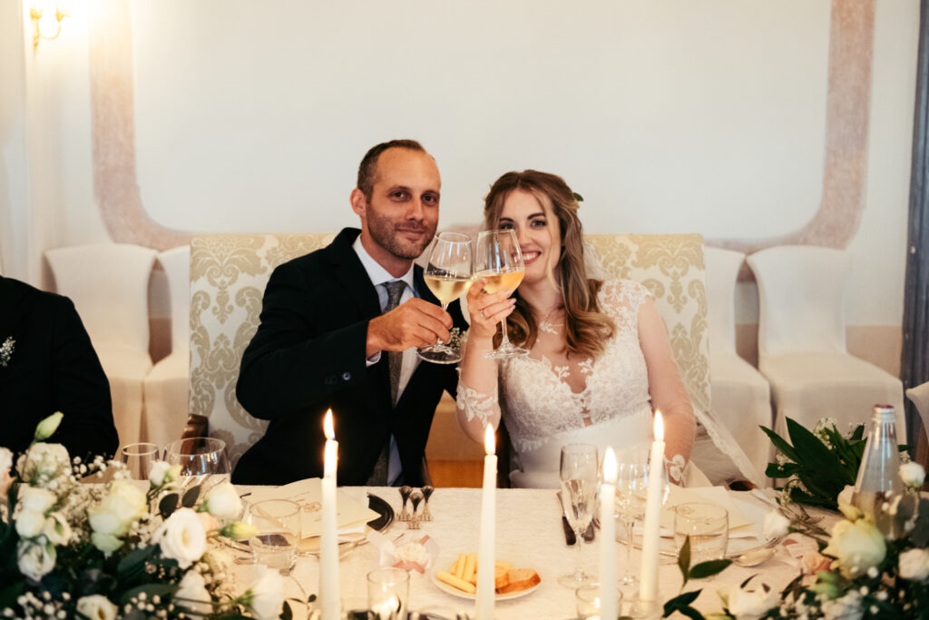 Bride and groom toasting during their elegant Italy micro-wedding reception.