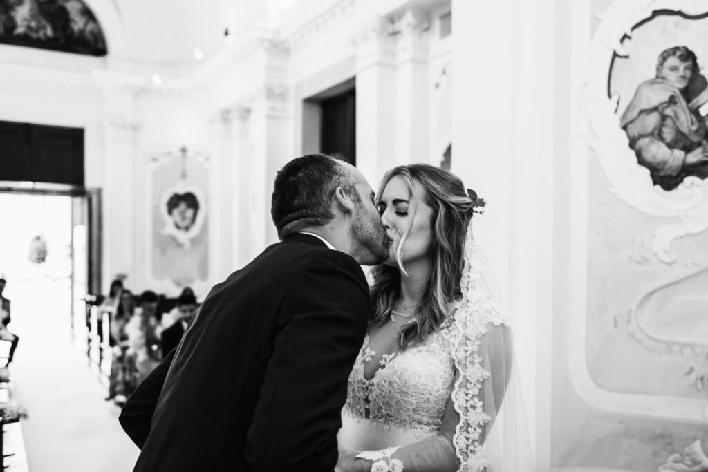 Kiss during the ceremony of an intimate wedding in Italy.