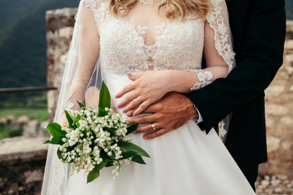 Detail of the bride’s lace dress and bouquet