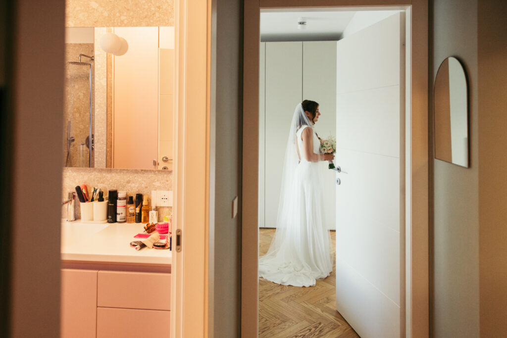 Bride seen from the hallway in her wedding dress, ready to leave