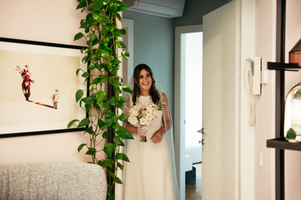 Bride walking out the room with her bouquet