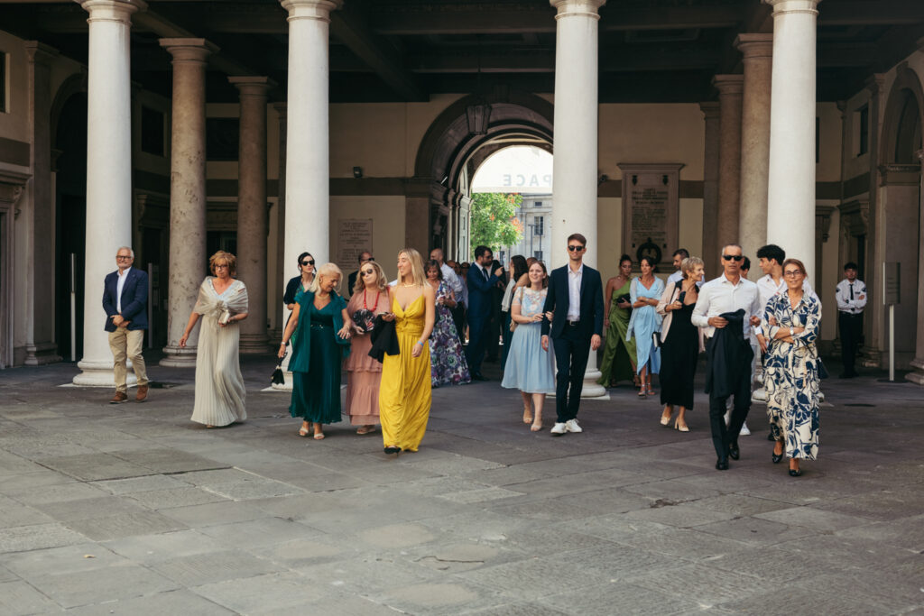 Wedding guests exiting the town hall and walking toward the square