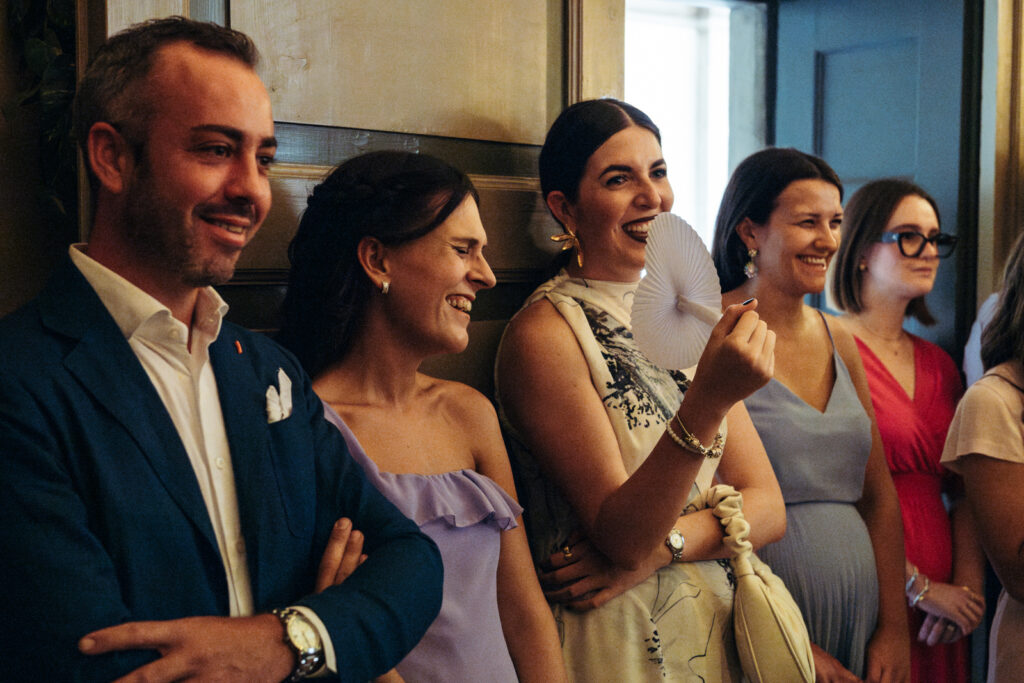 Guests smiling and reacting during the ceremony inside the town hall