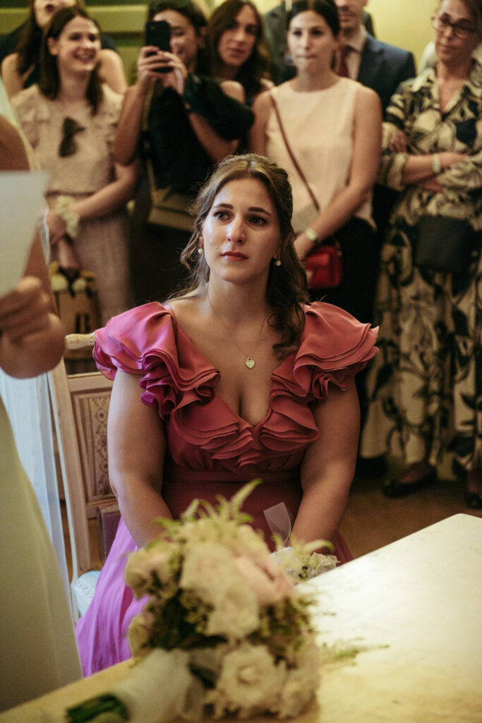Bridesmaid seated watching the vows moment