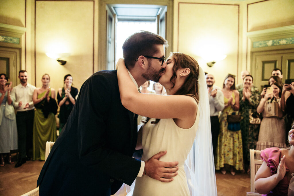 Newlyweds sharing their first kiss in the municipal wedding hall