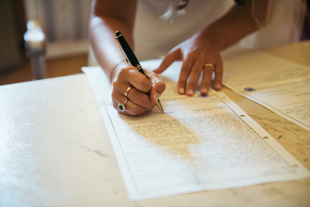 Close-up of bride signing the marriage certificate in Bergamo town hall