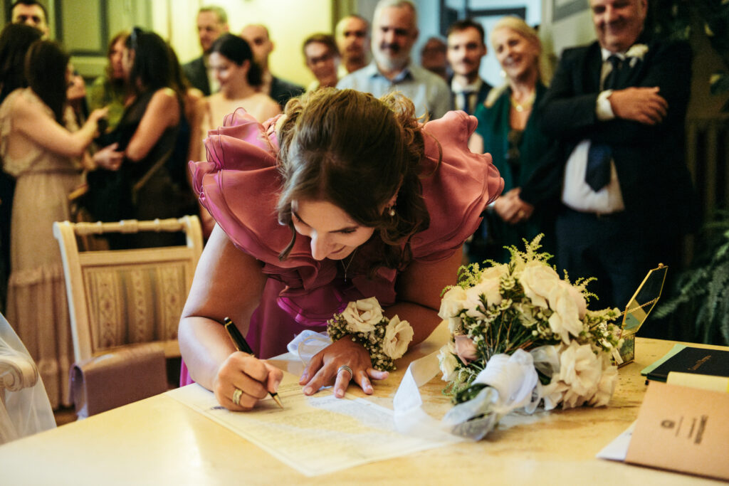 Witness signing the official marriage register during the civil ceremony