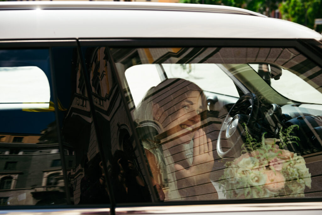 Reflection of the couple and villa facade in the wedding car window