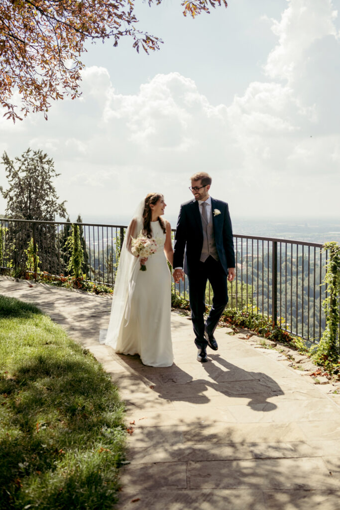 Couple strolling under the sun with panoramic views after their villa wedding