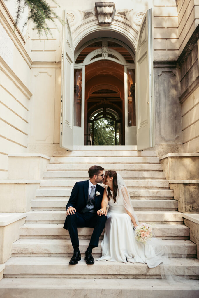 Couple sitting on the marble stairs of Villa Elena after their intimate ceremony