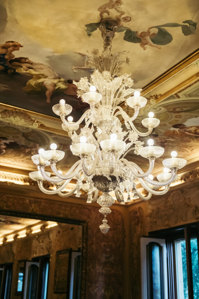 Crystal chandelier hanging from the richly decorated wedding hall