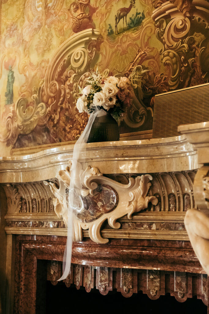Floral centerpiece on the ornate fireplace mantel at Villa Elena