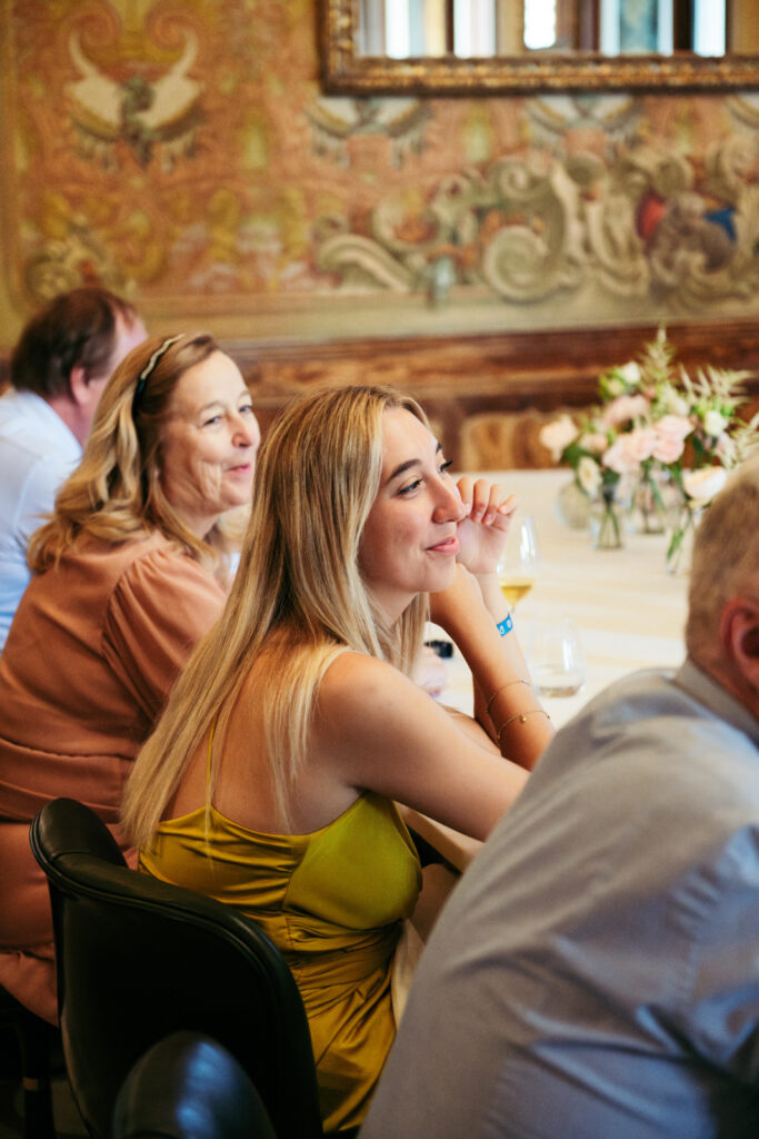 Wedding guest smiling during the speeches inside Villa Elena’s frescoed dining room
