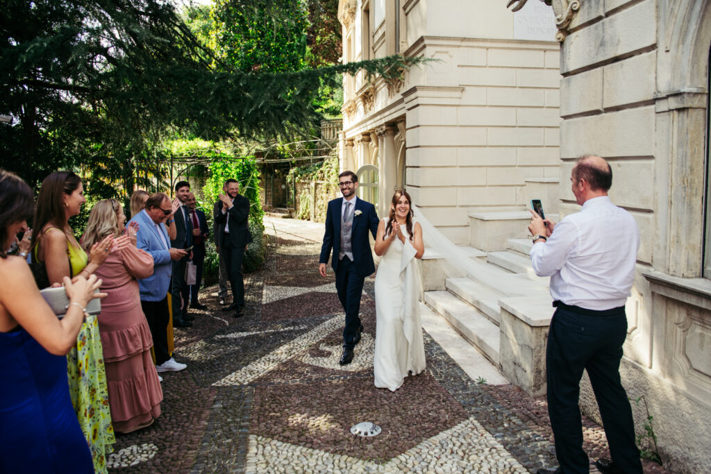 Bride and groom walking hand in hand through the courtyard of Villa Elena