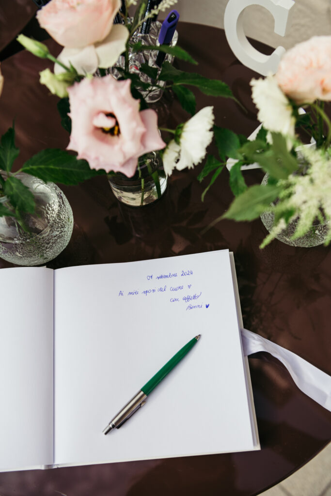 Guest book with handwritten note and floral decoration at an intimate wedding reception