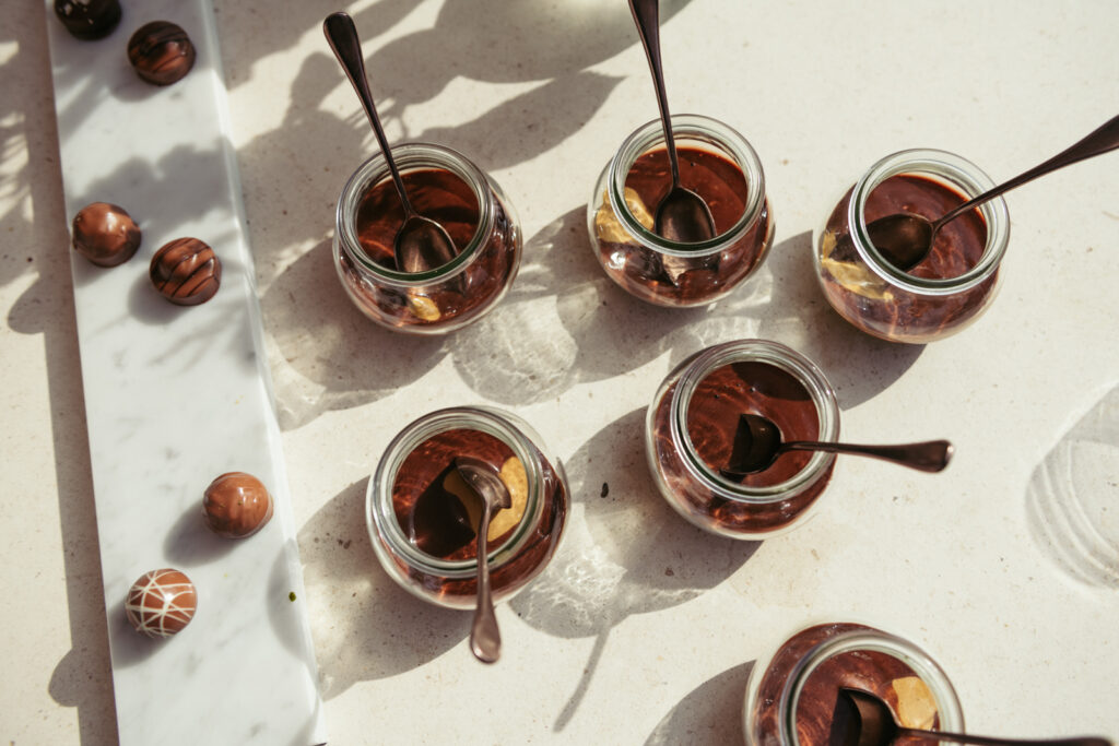 Wedding dessert table with individual chocolate mousse cups served outdoors