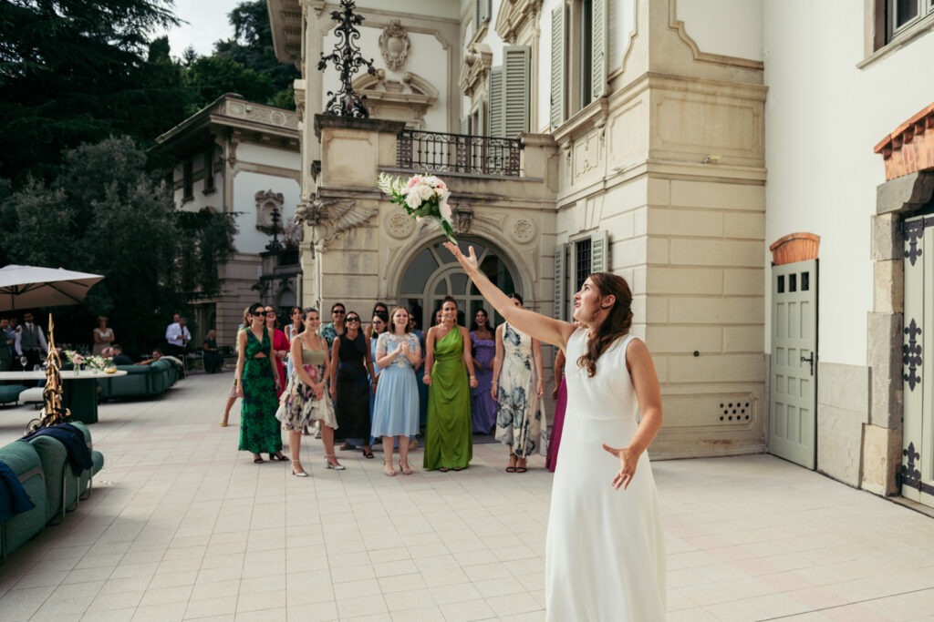 Bride throwing the bouquet in the square in front of Villa Elena