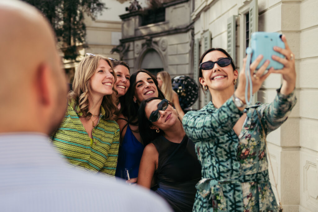 Friends taking a joyful selfie at an Italian wedding in Bergamo