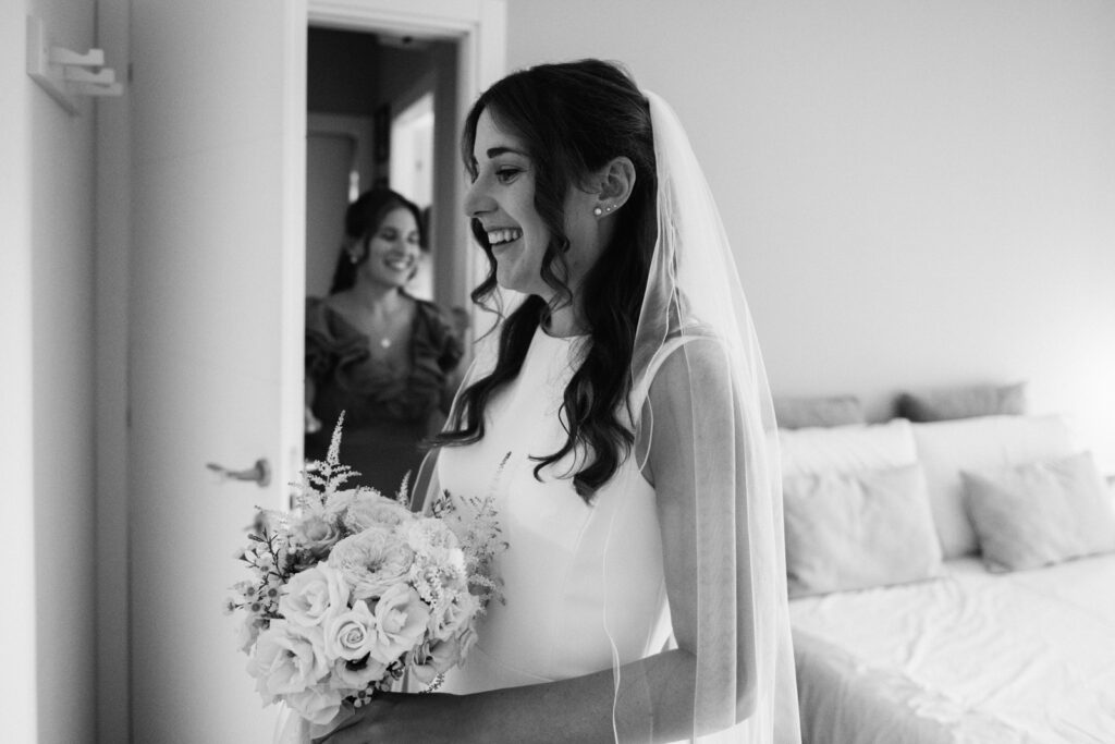 Bride smiling while holding her bouquet on the morning of her Bergamo wedding