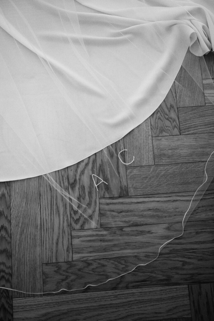 Wedding veil with embroidered initials on wooden floor before the ceremony in Bergamo