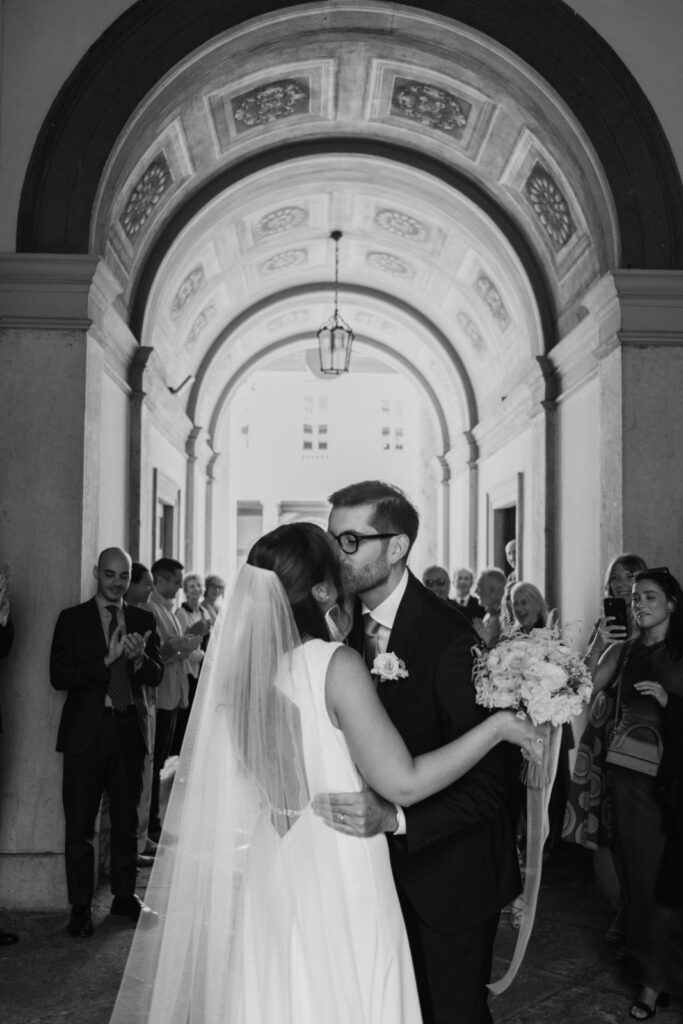 Bride and groom kissing in the elegant hallway of Comune di Bergamo