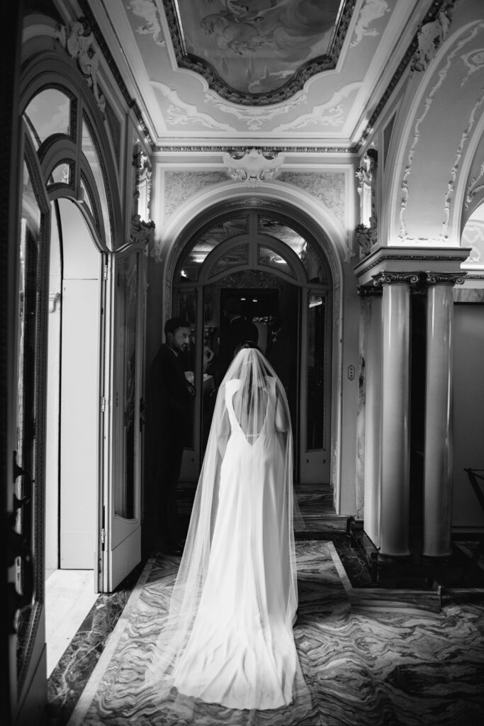 Back view of bride walking through arched hallway in elegant Italian villa