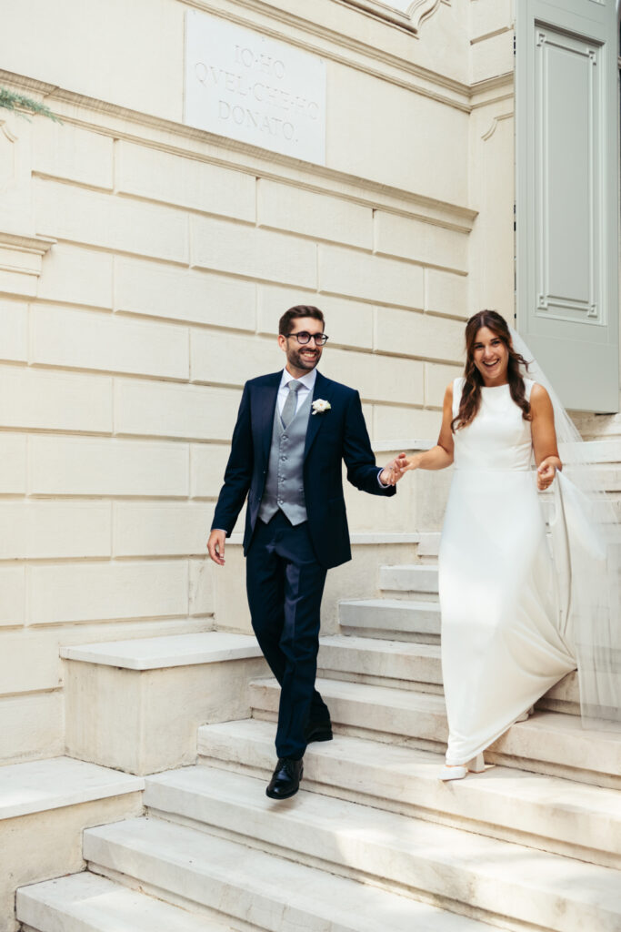 Couple walking down white marble steps at their romantic wedding at Villa Elena in Bergamo