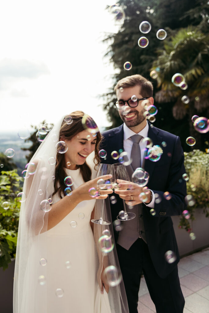Bride and groom blowing bubbles during their intimate wedding in Bergamo, Italy, at Villa Elena