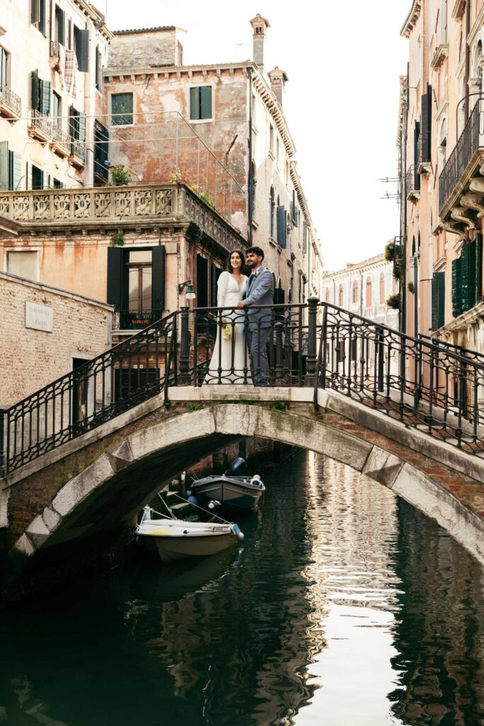 Couple embracing on a bridge over a canal during their Venice elopement