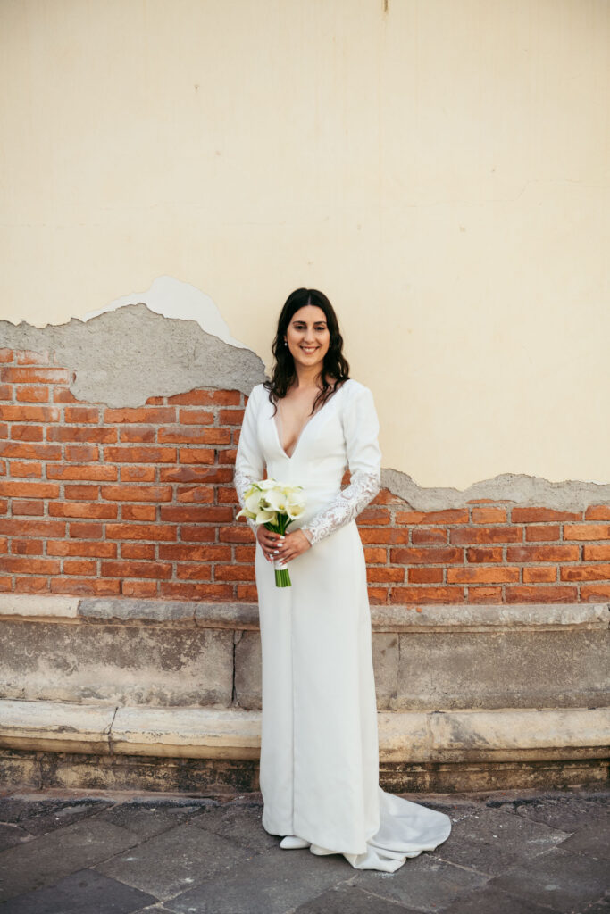 Full-length bridal portrait in wedding dress and bouquet in Venice before elopement