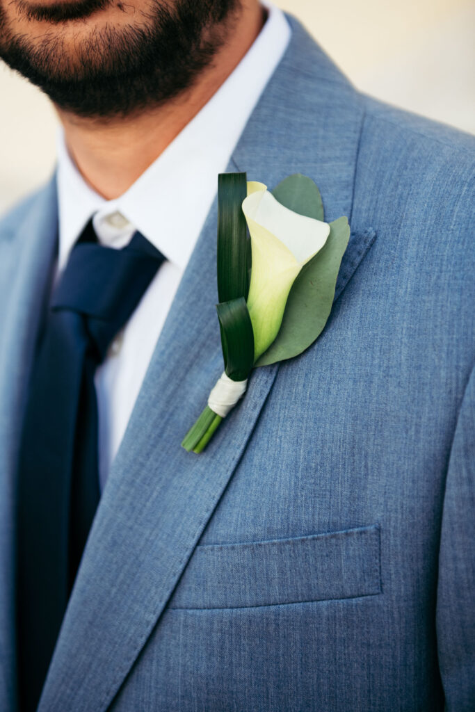 Close-up of groom’s boutonnière on light blue suit during symbolic wedding in Venice