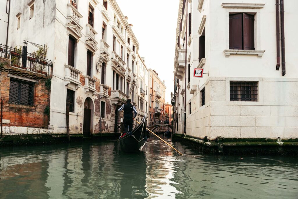 Quiet canal in Venice with gondola passing under a bridge during symbolic wedding day