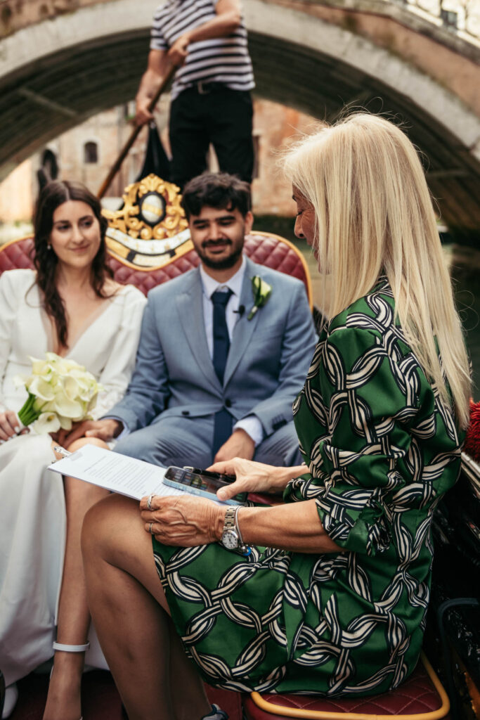 Venetian elopement ceremony with couple and officiant exchanging vows on a gondola