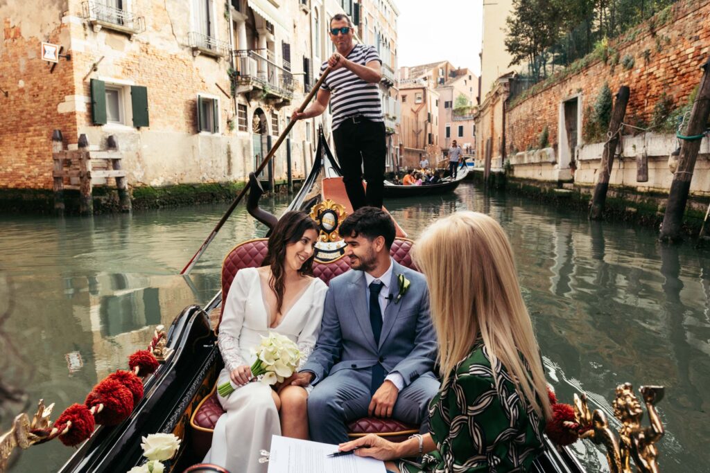 Symbolic wedding ceremony in Venice with officiant on gondola and couple exchanging vows