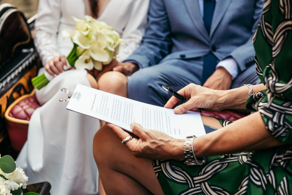 Close-up of handwritten vows during symbolic wedding in Venice, with bridal bouquet