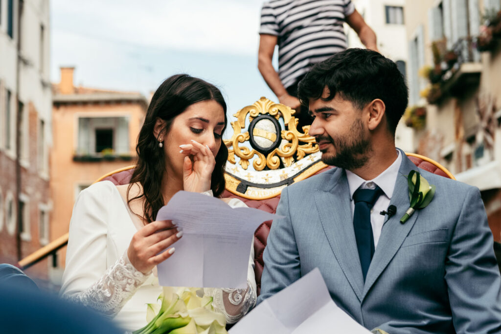 Bride wiping away tears while exchanging vows during symbolic wedding on a gondola in Venice Bride wiping away tears while exchanging vows during symbolic wedding on a gondola in Venice