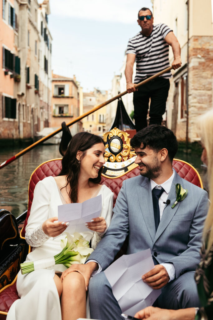 Bride laughing while holding her vows, sharing a moment with the groom during Venice elopement