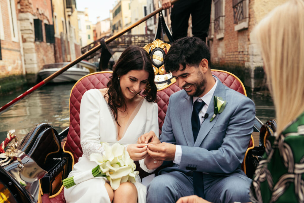 Groom placing the ring on bride’s hand during intimate symbolic ceremony on a gondola