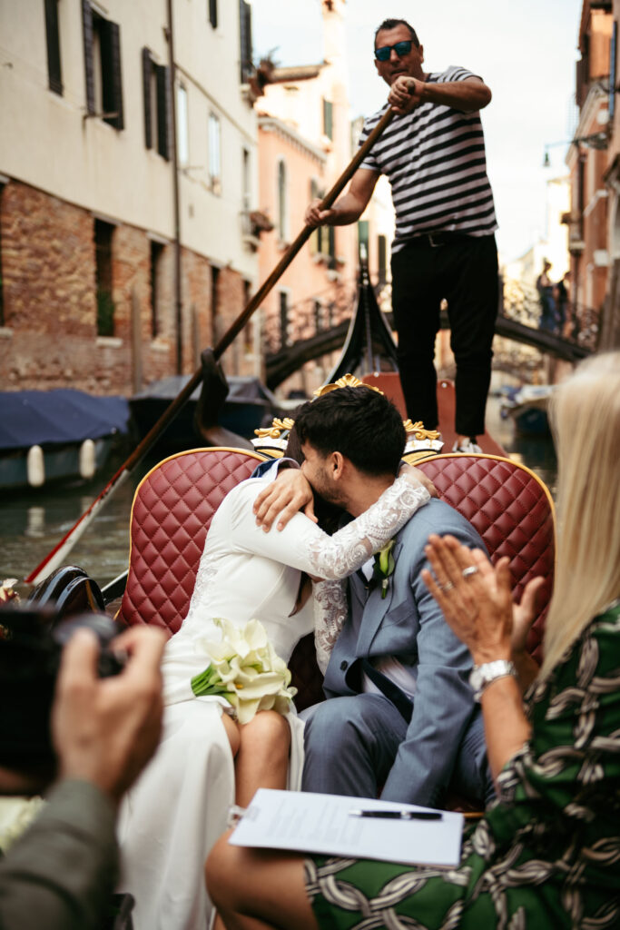 Emotional embrace during symbolic wedding ceremony on a gondola in Venice