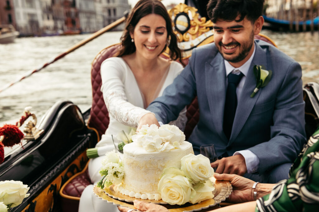 Venetian gondola ride during symbolic wedding with cake celebration