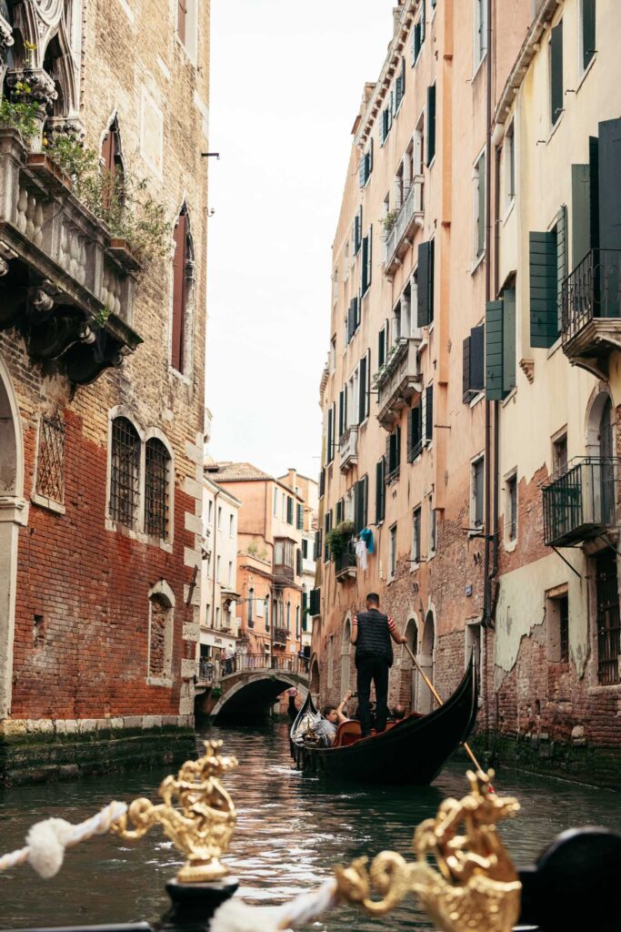 Romantic gondola ride through narrow canal streets during Venice elopement
