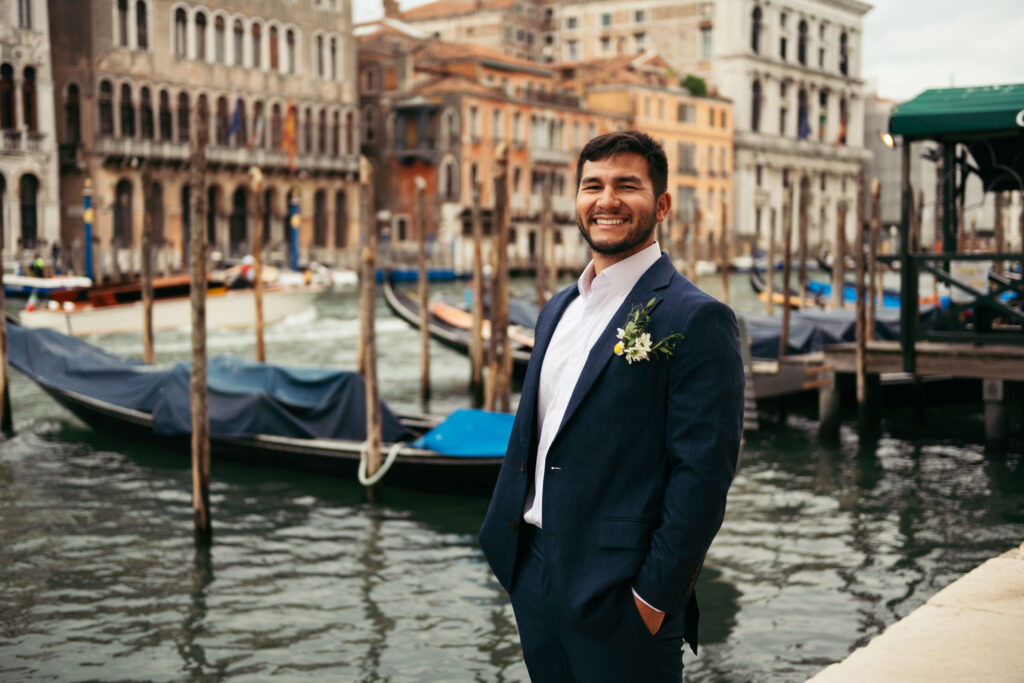 Groom smiling in front of the Grand Canal during their Venice elopement