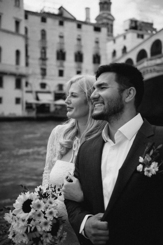Groom smiling with the bride on the gondola during their Venice elopement